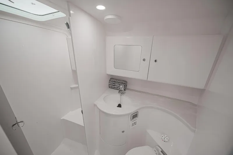  Yacht Photos Pics 2018 Intrepid 407 Cuddy boat bathroom with modern white fixtures and storage cabinets.