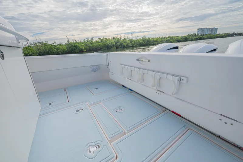  Yacht Photos Pics 2018 Intrepid 407 Cuddy boat deck with storage compartments, scenic water and greenery view.