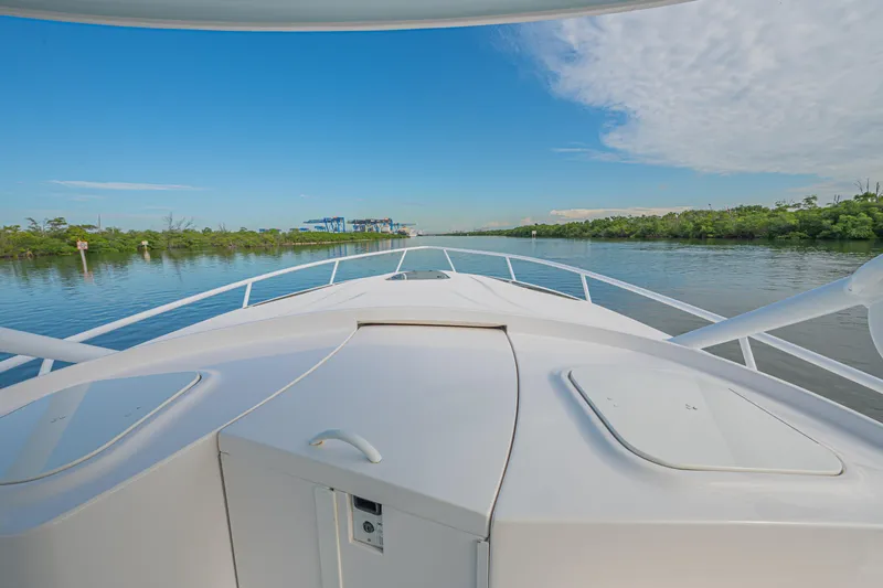  Yacht Photos Pics 2018 Intrepid 407 Cuddy cruising on a serene river under a clear blue sky.
