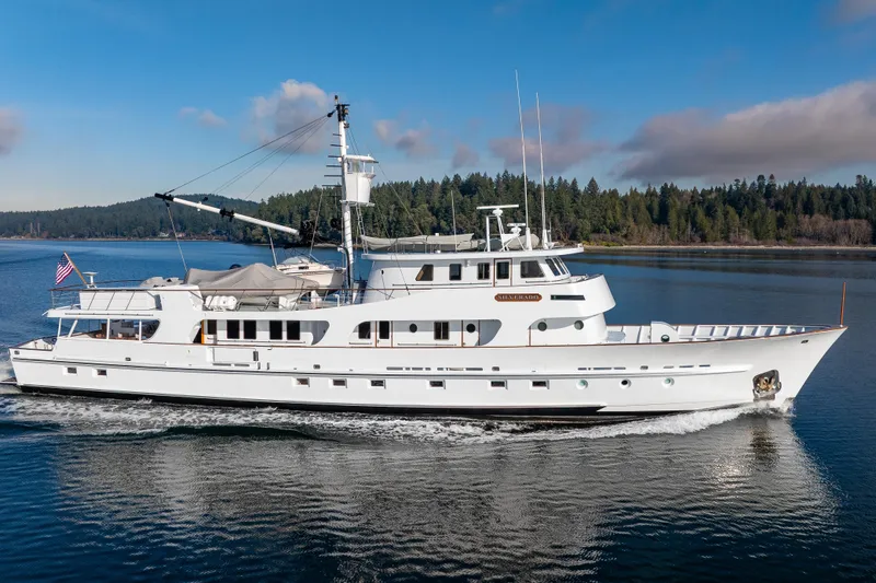 Silverado Yacht Photos Pics Vintage 1974 Willard 1201 yacht cruising on a serene lake with forested shoreline.