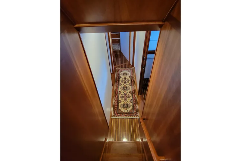 Nighthawk Yacht Photos Pics Interior of 1999 Lyman-Morse pilothouse with wooden stairs and decorative rug.