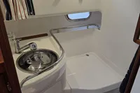 Compact bathroom in 2006 Nimbus 350 Coupe with sink, shower, and porthole window.