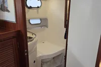 Nimbus 350 Coupe 2006 yacht bathroom with porthole, sink, and toilet.