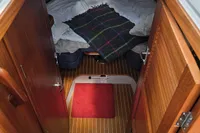 Interior cabin view of 2006 Nimbus 350 Coupe with wooden doors and cozy bedding.