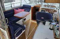 Interior of a 2006 Nimbus 350 Coupe yacht with seating, table, and helm.