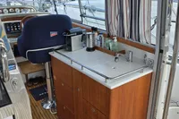 Interior of 2006 Nimbus 350 Coupe yacht with wooden cabinetry and helm station.