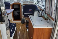 Interior of a 2006 Nimbus 350 Coupe boat with wooden flooring and compact kitchen area.