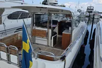 Nimbus 350 Coupe 2006 docked, featuring Swedish flag and open cockpit.