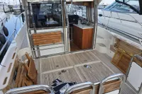 Nimbus 350 Coupe 2006 yacht interior with wooden deck and compact kitchen area.