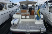 2006 Nimbus 350 Coupe yacht docked, featuring Swedish flag and spacious deck.