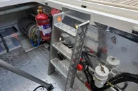 Engine compartment of 2006 Nimbus 350 Coupe with fire extinguisher and metal ladder.