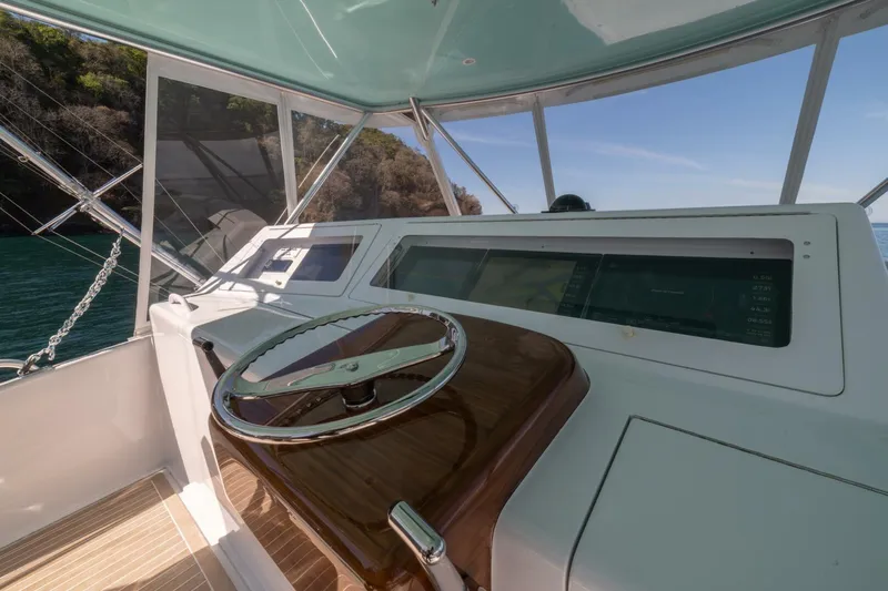 Scandaloso Yacht Photos Pics Helm of 2006 Viking 56 yacht with modern navigation equipment and scenic ocean view.