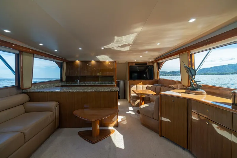 Scandaloso Yacht Photos Pics Luxurious interior of 2006 Viking 56 yacht with elegant wood finishes and scenic ocean views.