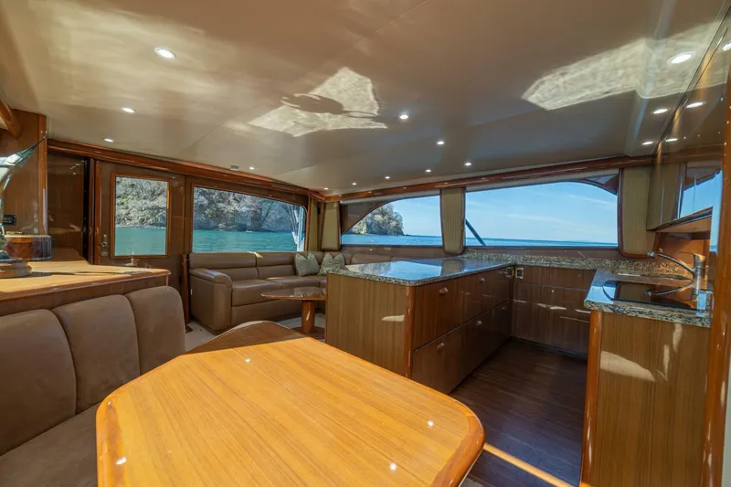 Scandaloso Yacht Photos Pics Luxurious interior of a 2006 Viking 56 yacht with elegant wood finishes and ocean view.