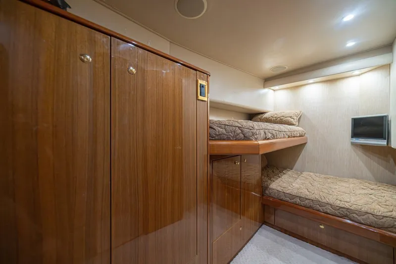Scandaloso Yacht Photos Pics Interior of 2006 Viking 56 yacht with wooden cabinets and cozy bunk beds.