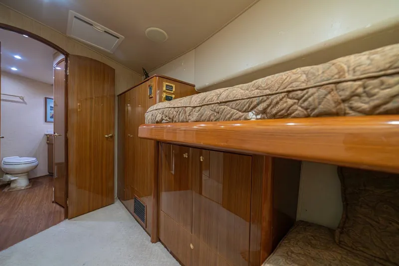 Scandaloso Yacht Photos Pics Interior of 2006 Viking 56 yacht with wooden cabinetry and cozy sleeping area.
