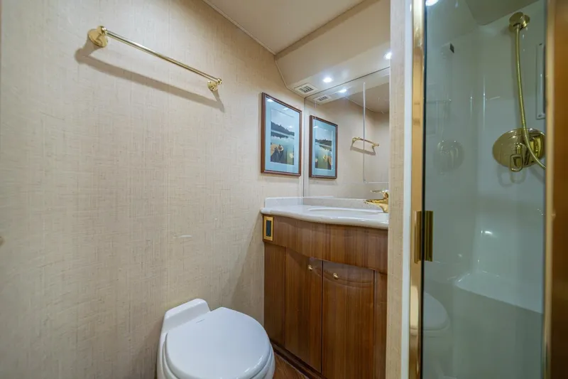 Scandaloso Yacht Photos Pics Luxurious bathroom in 2006 Viking 56 yacht with wood cabinetry and gold fixtures.