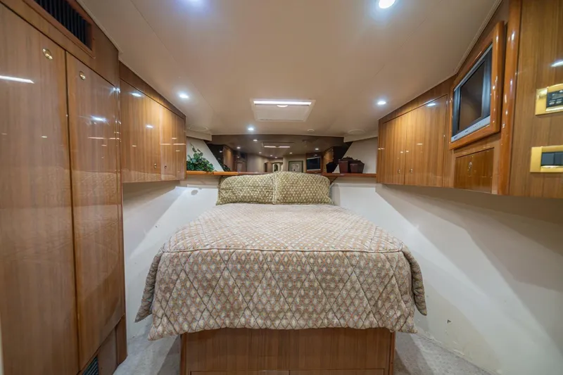 Scandaloso Yacht Photos Pics Luxurious cabin interior of a 2006 Viking 56 yacht with wood paneling and cozy bedding.