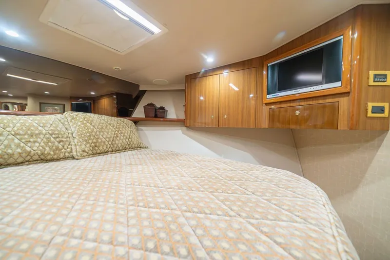 Scandaloso Yacht Photos Pics Luxurious cabin interior of a 2006 Viking 56 yacht with wood paneling and TV.