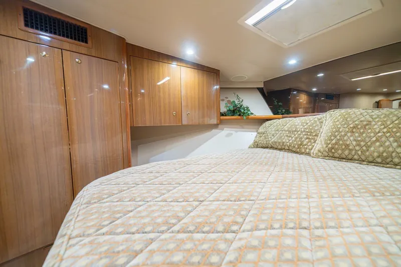 Scandaloso Yacht Photos Pics Luxurious cabin interior of a 2006 Viking 56 yacht with wood paneling and plush bedding.