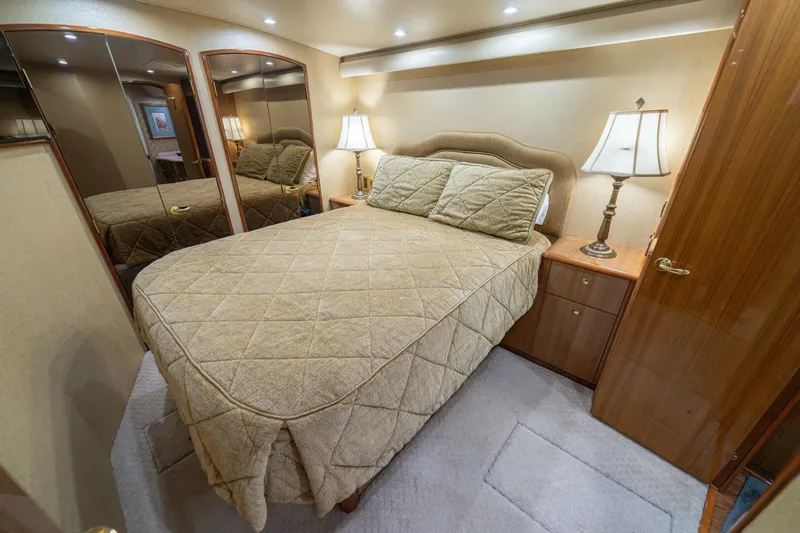 Scandaloso Yacht Photos Pics Luxurious bedroom interior of 2006 Viking 56 yacht with elegant bedding and mirrored closet.