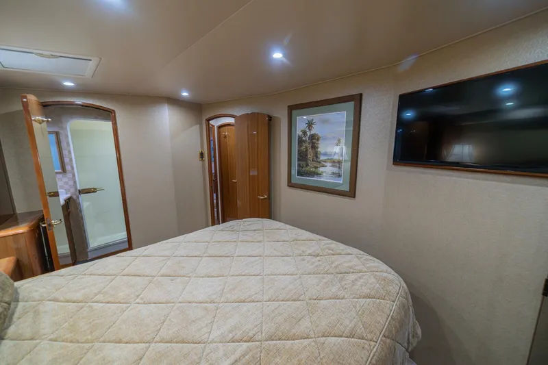 Scandaloso Yacht Photos Pics Luxurious cabin interior of a 2006 Viking 56 yacht with bed, TV, and artwork.