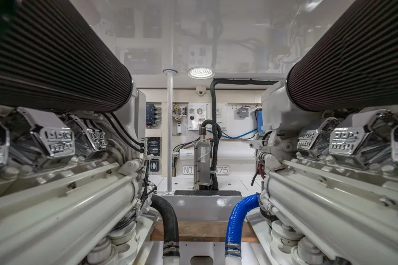 Scandaloso Yacht Photos Pics Engine room of a 2006 Viking 56 yacht, showcasing dual engines and mechanical components.