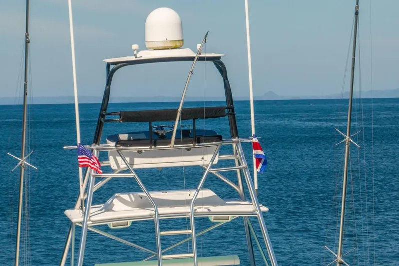 Scandaloso Yacht Photos Pics 2006 Viking 56 yacht tower with flags, set against a serene ocean backdrop.