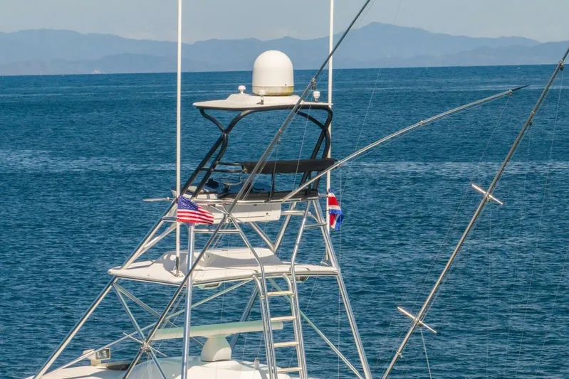 Scandaloso Yacht Photos Pics 2006 Viking 56 yacht tower with flags, set against a serene ocean backdrop.