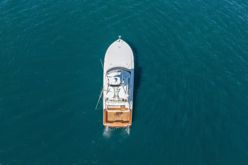 Scandaloso Yacht Photos Pics Aerial view of 2006 Viking 56 yacht cruising on open blue water.
