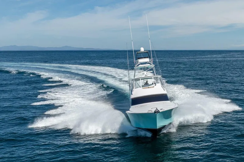 Scandaloso Yacht Photos Pics 2006 Viking 56 yacht cruising swiftly on open ocean waters.