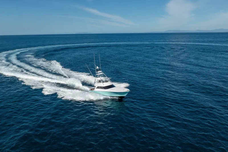 Scandaloso Yacht Photos Pics 2006 Viking 56 yacht cruising on open ocean, creating a circular wake pattern.