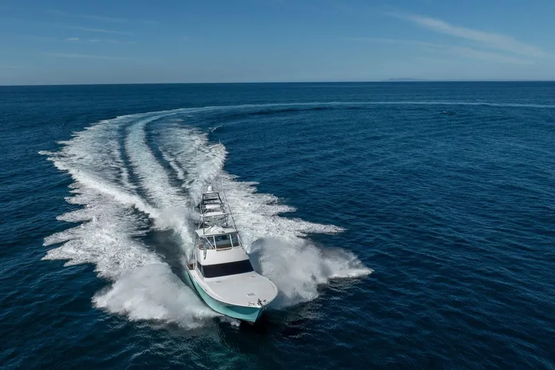 Scandaloso Yacht Photos Pics 2006 Viking 56 yacht cruising swiftly on open ocean waters.