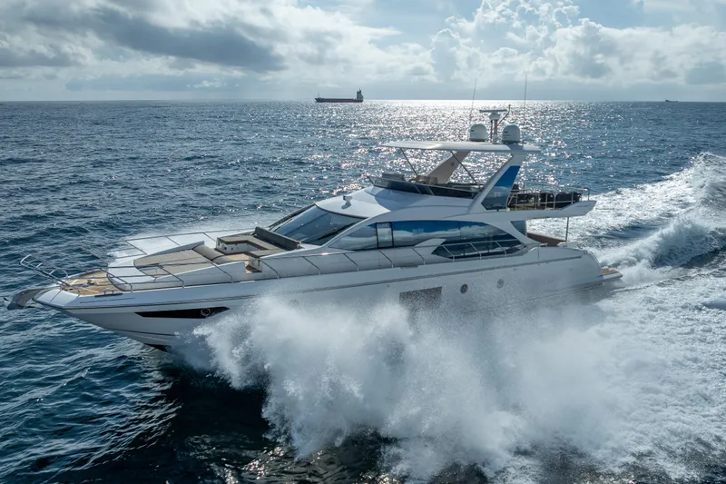  Yacht Photos Pics Luxurious 2019 Azimut 66 yacht cruising through ocean waves under a cloudy sky.