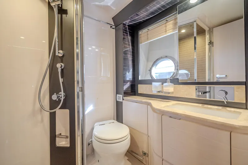  Yacht Photos Pics Luxurious bathroom in 2019 Azimut 66 yacht with modern fixtures and porthole window.