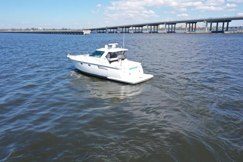  Yacht Photos Pics 2019 Tiara Yachts Sovran cruising on a sunny day near a bridge.