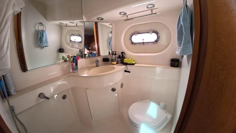  Yacht Photos Pics Luxurious bathroom in 2019 Tiara Yachts Sovran, featuring modern fixtures and porthole window.
