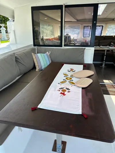 Vahevala Yacht Photos Pics Cozy seating area on 2019 Fountaine Pajot Lucia 40 catamaran with decorative table runner.