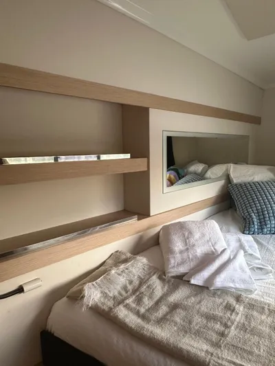 Vahevala Yacht Photos Pics Cozy cabin interior of 2019 Fountaine Pajot Lucia 40 catamaran with bed and shelves.