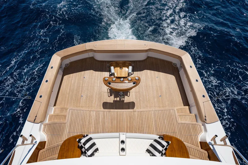 New Build Yacht Photos Pics 2026 Viking 90 Sky Bridge yacht deck with wooden flooring, ocean view, and seating area.