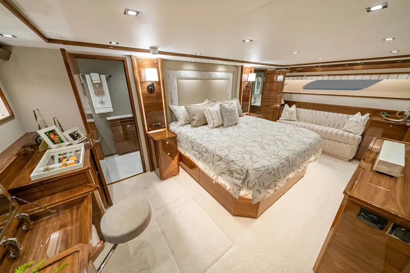 New Build Yacht Photos Pics Luxurious bedroom interior of 2026 Viking 90 Sky Bridge yacht, featuring elegant wood finishes.