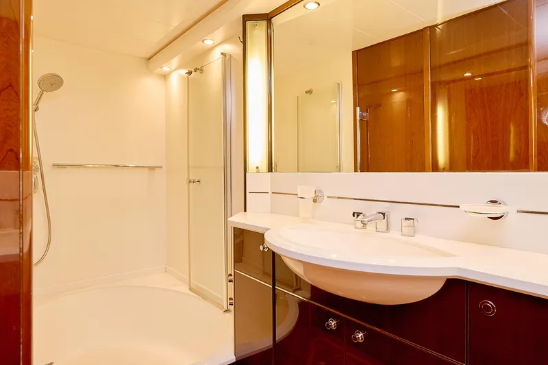  Yacht Photos Pics Luxurious yacht bathroom with modern fixtures, glass shower, and elegant wood paneling. Princess 23M, 2009.