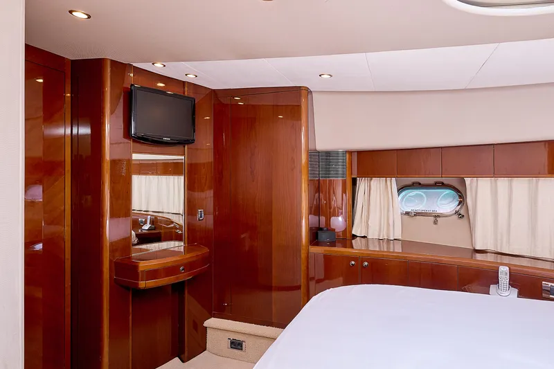  Yacht Photos Pics Luxurious cabin interior of 2009 Princess 23M yacht with wood paneling and porthole window.