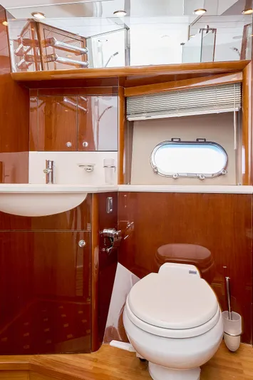  Yacht Photos Pics Luxurious yacht bathroom with wooden cabinetry, sink, and porthole window in a 2009 Princess 23M.
