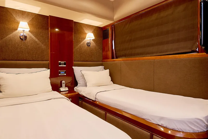  Yacht Photos Pics Luxurious twin cabin interior on 2009 Princess 23M yacht, featuring elegant wood paneling and soft lighting.