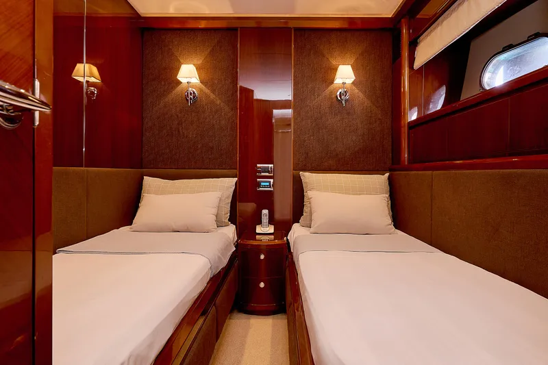  Yacht Photos Pics Luxurious twin cabin interior on 2009 Princess 23M yacht, featuring elegant wood paneling and soft lighting.