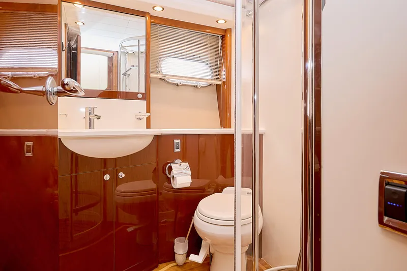  Yacht Photos Pics Luxurious yacht bathroom with modern fixtures, wooden accents, and a glass shower enclosure.