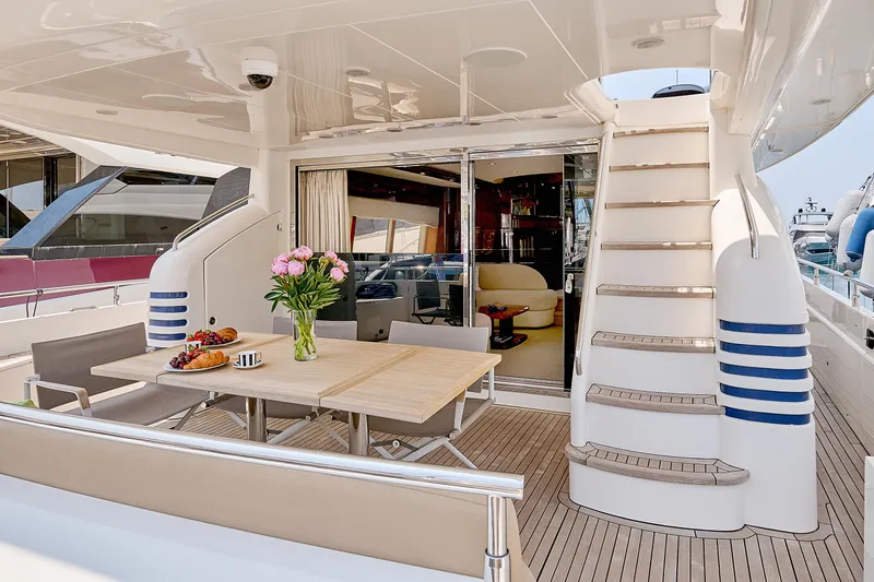  Yacht Photos Pics Luxurious 2009 Princess 23M yacht deck with dining area and elegant staircase.