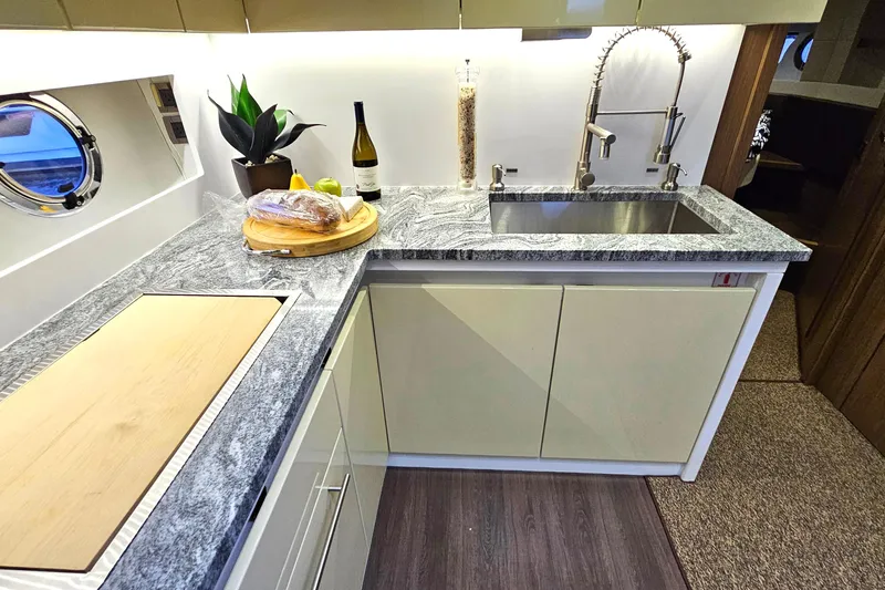 Magic Carpet Yacht Photos Pics Modern kitchen in 2015 Beneteau Gran Turismo 49 yacht with sleek countertops and stainless steel sink.