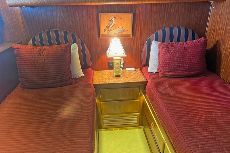 Long Tail Yacht Photos Pics Interior of 1985 Hatteras 58 Motor Yacht with twin beds and elegant wood paneling.
